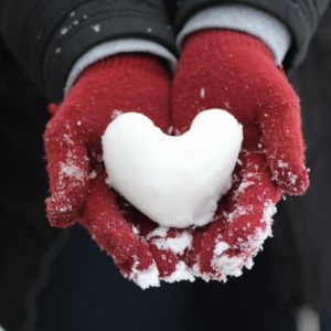person holding heart-shaped snow